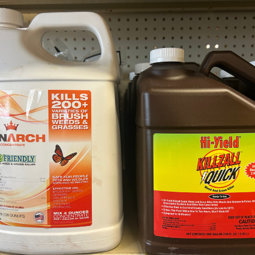 Containers of herbicides are displayed on a shelf. The left jug is white, labeled 