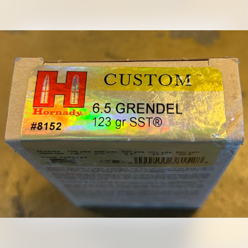 Box of Hornady ammunition for 6.5 Grendel, 123 gr SST, with a holographic label and red Hornady logo on a wooden surface.