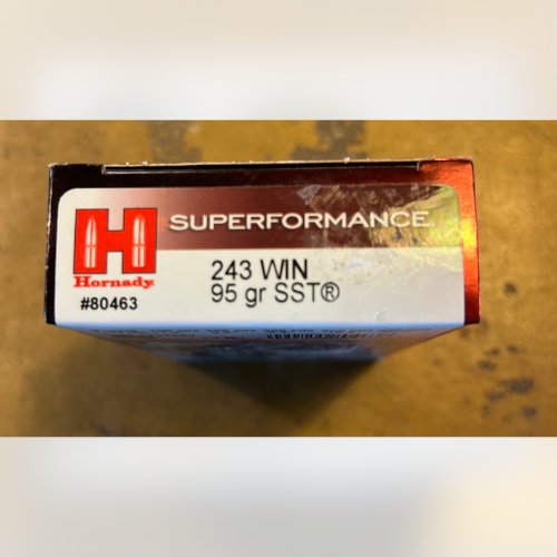 Box of Hornady Superformance .243 WIN ammunition, 95 gr SST, viewed from the top with red and white labeling on a wooden surface.