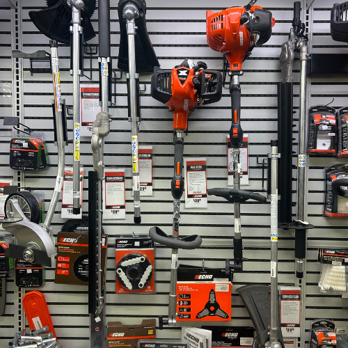 A wall display of gardening tools and accessories featuring a variety of trimmers, edgers, and attachments hanging neatly, showcasing Echo products.